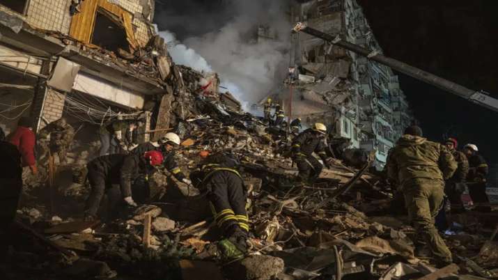 India Tv - Emergency workers clear the rubble after a Russian rocket hit a multistory building leaving many people under debris in the southeastern city of Dnipro