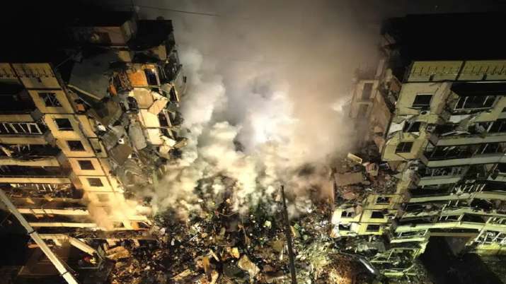 India Tv - Emergency workers clear debris after a Russian rocket hit a multi-storey building in the southeastern city of Dnipro