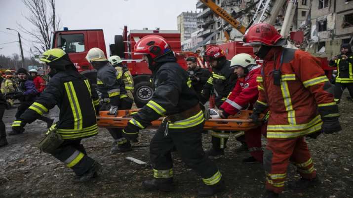 India Tv - Emergency workers clear the rubble after a Russian rocket hit a multistory building leaving many people under debris in the southeastern city of Dnipro
