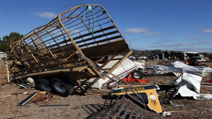 India Tv - Debris stretches across a field after a tornado ripped through Central Alabama
