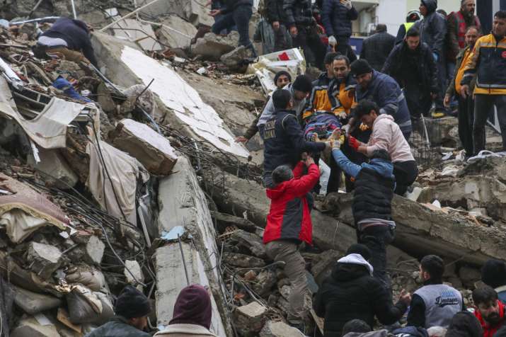 India Tv - People and emergency teams rescue a man lying on a stretcher from a collapsed building in Adana.