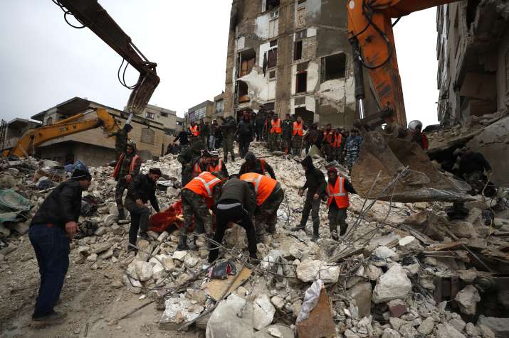 India Tv - Rescuers trying to reach people trapped inside collapsed buildings in Adana.