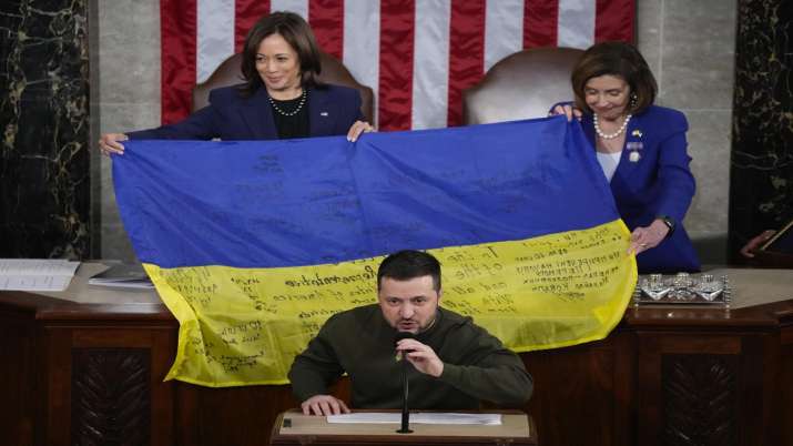 India Tv - Vice President Kamala Harris and then-House Speaker Nancy Pelosi of Calif., right, react as Ukrainian President Volodymyr Zelenskyy presents lawmakers with a Ukrainian flag autographed by front-line troops in Bakhmut.