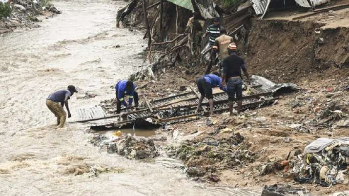 India Tv - Men salvage parts from their destroyed home, following heavy rains caused by Cyclone Freddy 