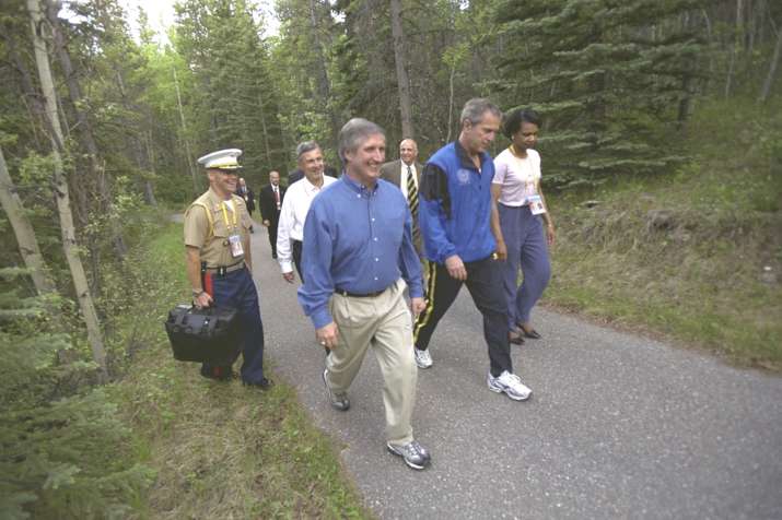 India Tv - President George W. Bush walks on the Delta Lodge grounds with Secretary of State Condoleezza Rice, White House Chief of Staff Andrew Card, and others, as an unidentified military aide carries the Presidential Emergency Satchel, during meetings of the G-8 Economic Summit in Kananaskis in 2002.