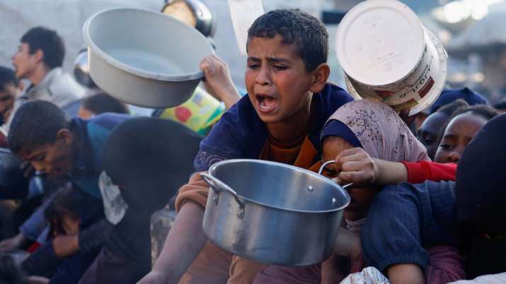 India Tv - A child reacts, as Palestinians wait to receive food during the Muslim holy fasting month of Ramadan