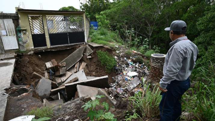 India Tv - A man looks at a house damaged by heavy rains in Veracruz, Mexico.