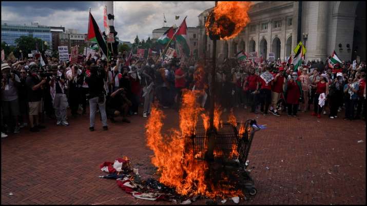 India Tv - Pro-Palestinian demonstrators burn a US flag and an effigy depicting Israeli Prime Minister Benjamin Netanyahu.