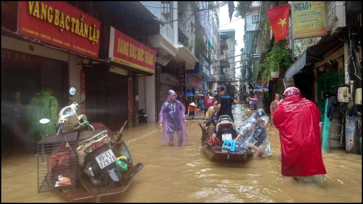 India Tv - People wade through a flooded street in Hanoi following the impact of Typhoon Yagi.