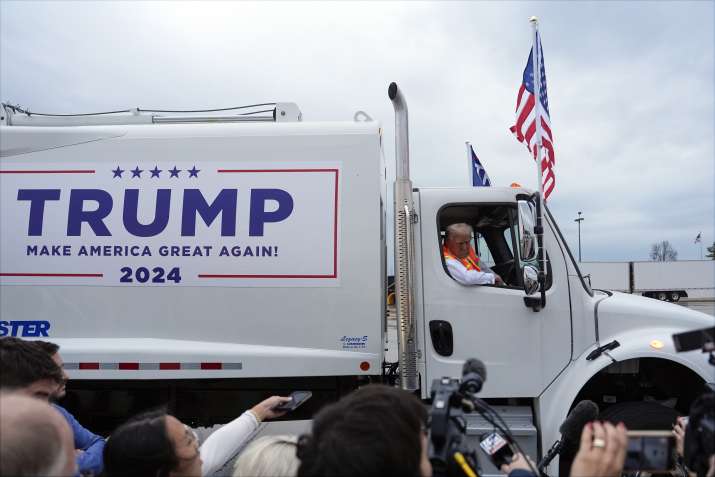 India Tv - Donald Trump talks to reporters as he sits in a garbage truck