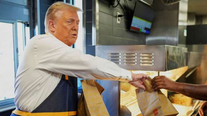 India Tv - Trump works behind the counter during a visit to McDonalds