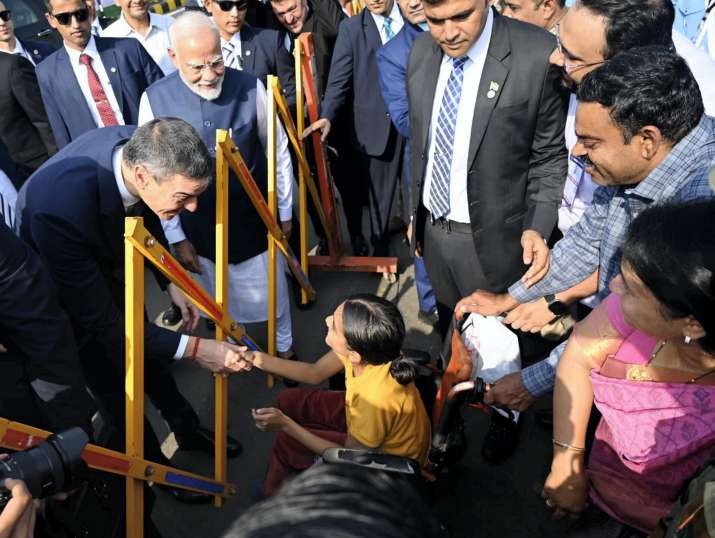 India Tv - Prime Minister Narendra Modi looks on as Spanish Prime Minister Pedro Sanchez interacts with a physi