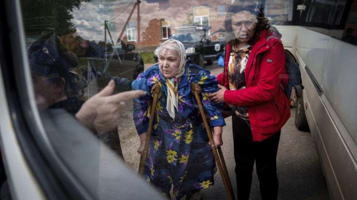 India Tv - People help Liudmila, 85, to sit into a bus after their evacuation from Vovchansk, Ukraine, Sunday, 