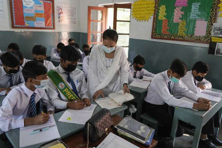 India Tv - Students wear mask to protect themselves from poor air quality due to increasing smog in the city as