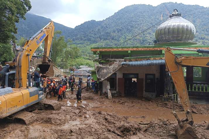 India Tv - Rescuers search for victims after a landslide that killed a number of people and left some others mi