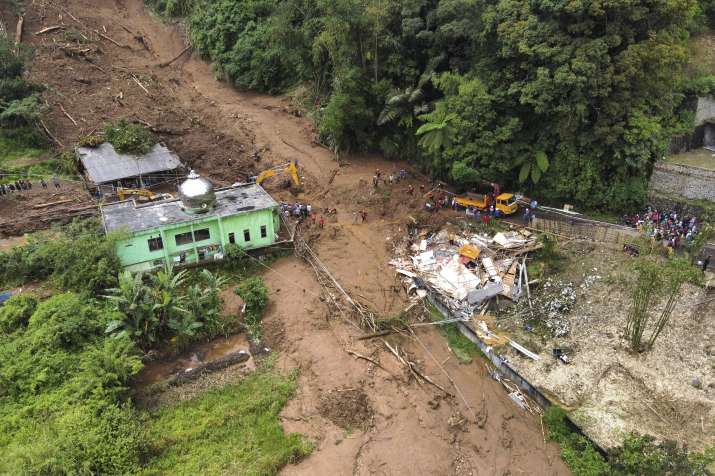 India Tv - Rescuers search for victims after a landslide that killed a number of people and left some others mi