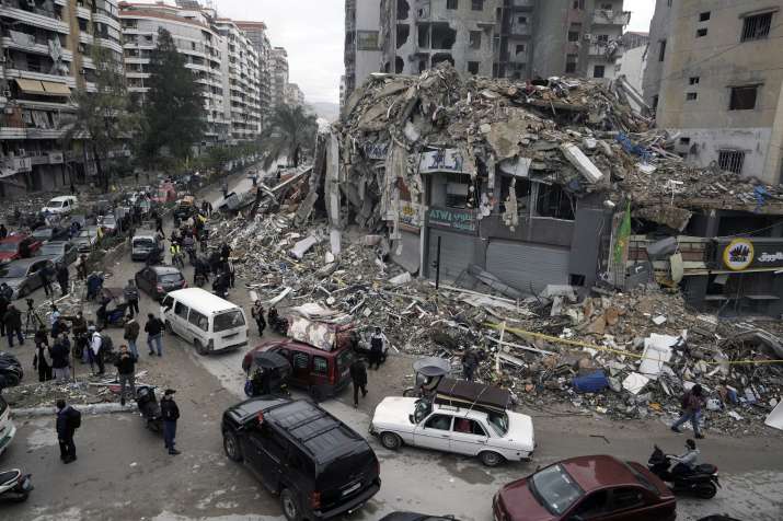 India Tv - People gather as vehicles drive near damaged buildings, in Beirut's southern suburbs, after a ceasef