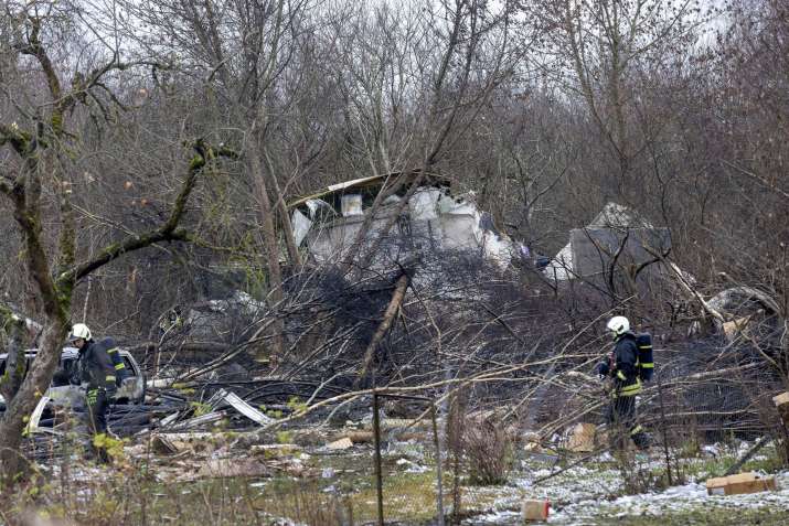 India Tv - Lithuanian police investigators work at the site where a DHL cargo plane crashed into a house near t