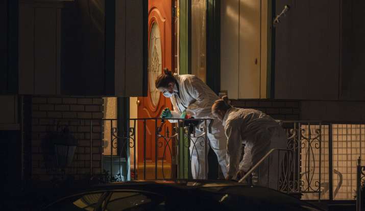 India Tv - Technicians investigate a crime scene where police say multiple family members were found dead insid