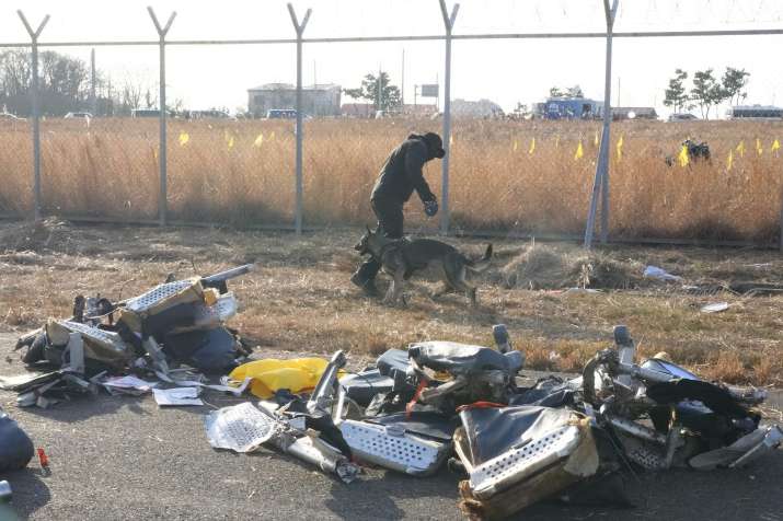 इंडिया टीवी - अग्निशामक और बचाव दल के सदस्य मुआन इंटरनेशनल में एक यात्री विमान के मलबे के पास काम करते हुए