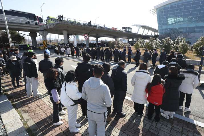 India Tv - Mourners wait to pay tribute to the victims of a plane fire at a memorial altar at Muan Internationa