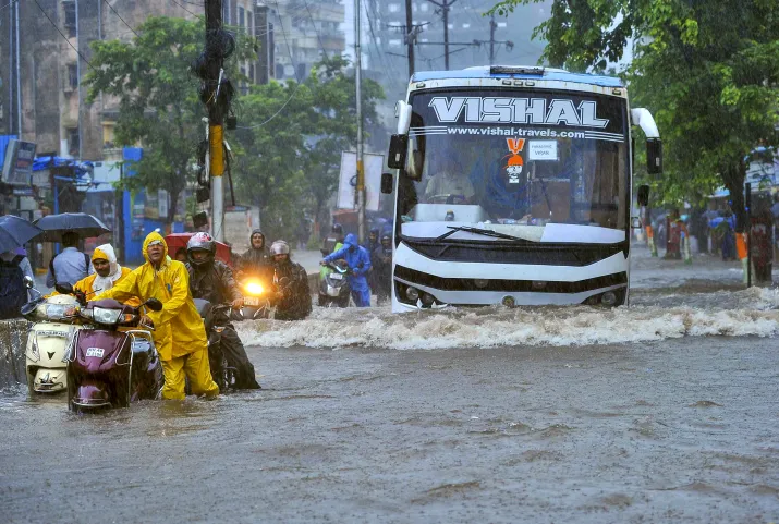 India Tv - Commuters struggled in knee-deep waters in Mumbai. 