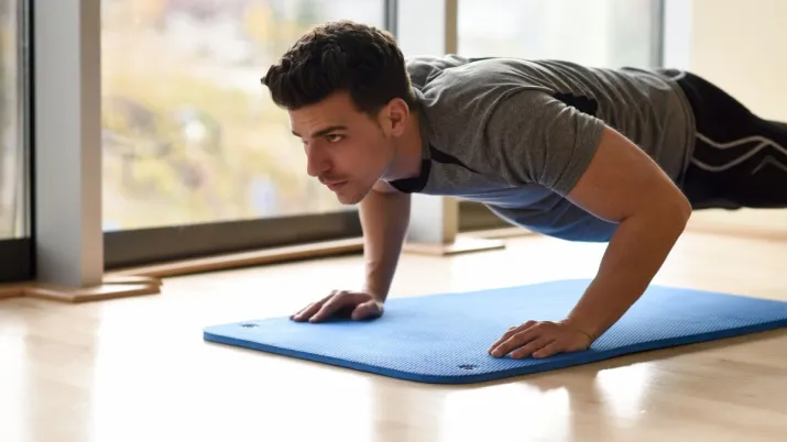 India Tv - Man doing push-ups on a yoga mat during a 15-minute full-body home workout