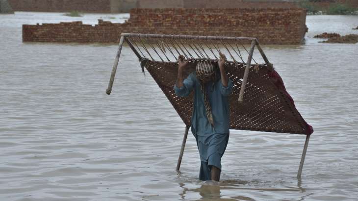 A man lifts a cot after rescuing from flood victims