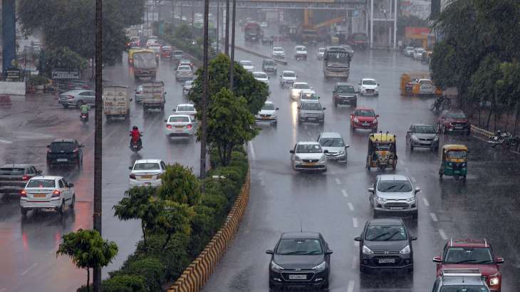 Vehicles ply on a road amid heavy rains, in Noida