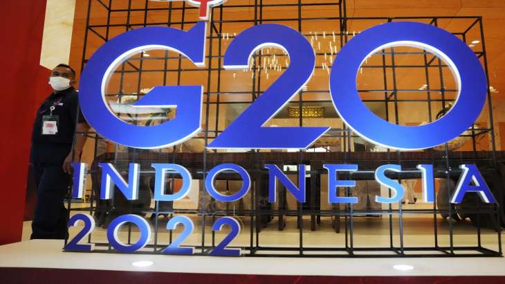 A security guard walks past a G20 sign during the 2nd G20