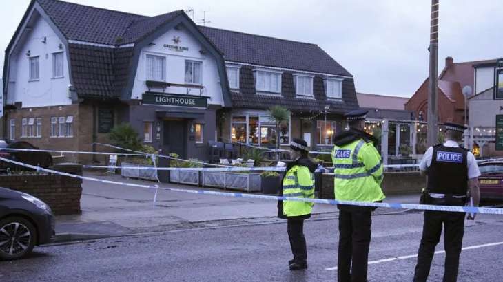 Police officers stand on duty at the Lighthouse Inn in