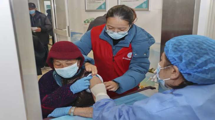 An elderly woman gets vaccinated against COVID-19 at a