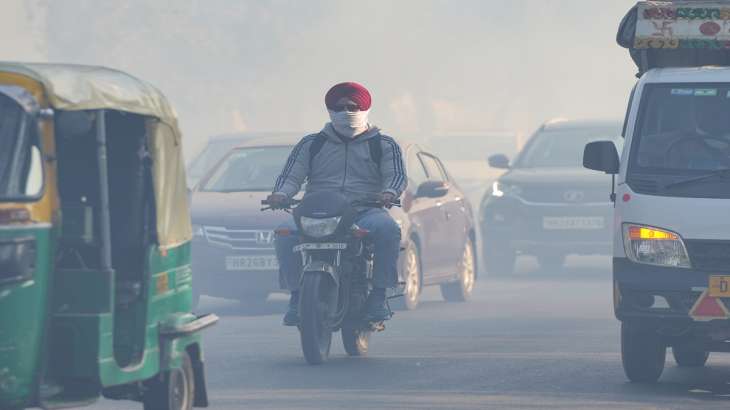 Commuters walk through smog in New Delhi.