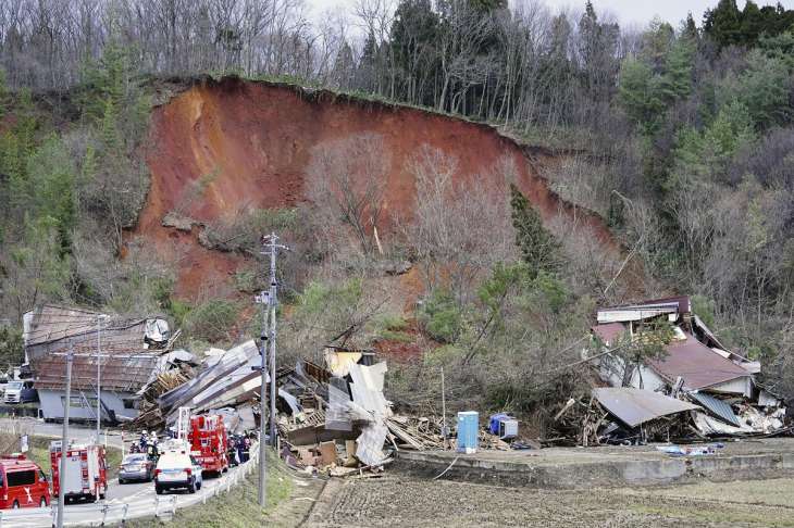 Rescuers gather at the site of a landslide in Tsuruoka,