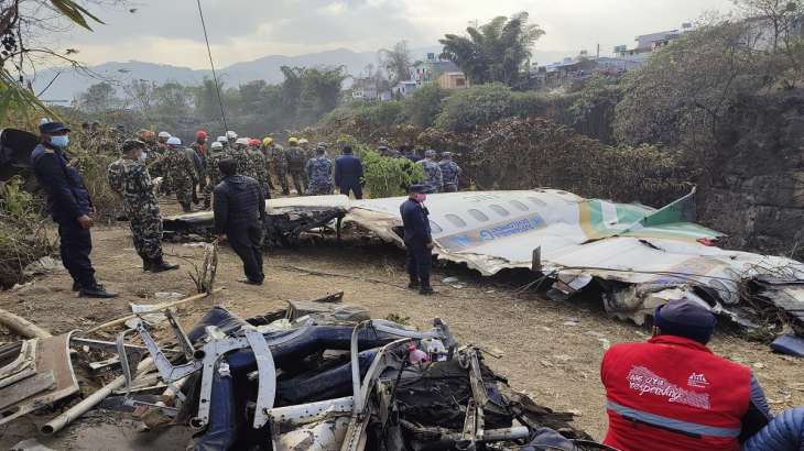 Rescue workers stand near the wreckage of the passenger plane