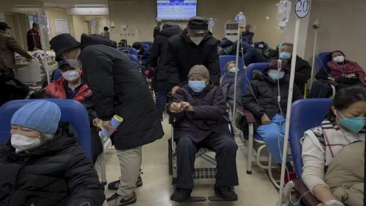 A man pushes an elderly woman past patients receiving