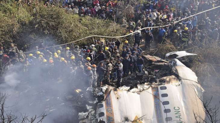 Nepalese rescue workers and civilians gather around the