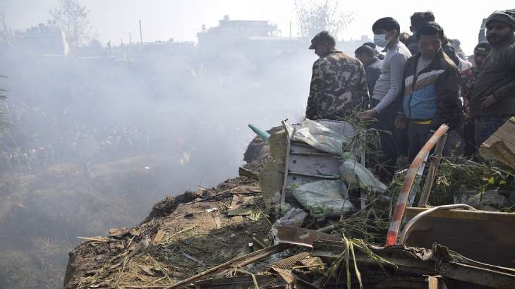 Nepalese rescue workers and civilians gather around the