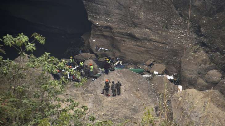 Nepalese rescue workers inspect the wreckage at the crash site