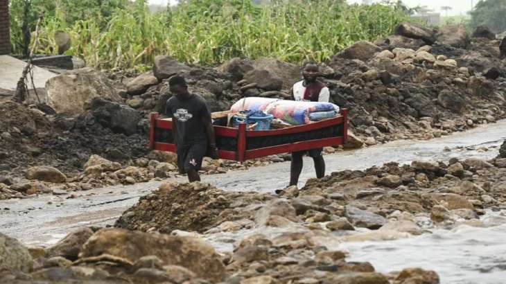Men transport their salvaged belongings in Chiradzulu,