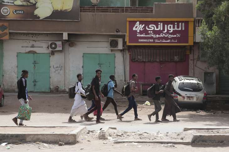 People walk past closed shops in Khartoum.