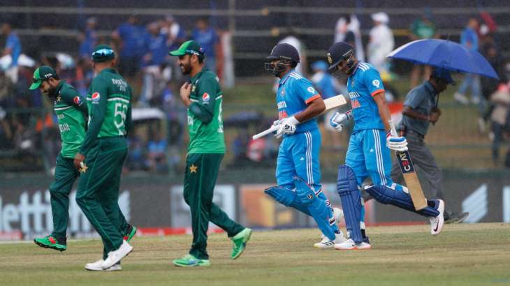 India and Pakistan players rush towards their pavilion as rain pours down