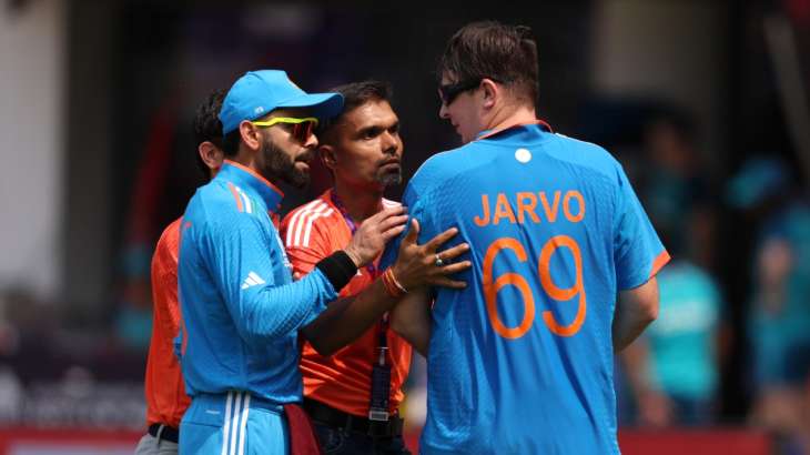 Pitch invader Jarvo being escorted by Virat Kohli during