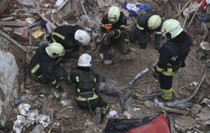 Authorities pulling the body of the boy from the rubble in