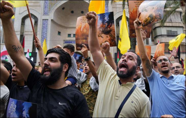 Hezbollah supporters raise slogans in solidarity with