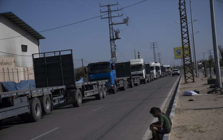 Palestinian trucks line up to receive humanitarian aid from