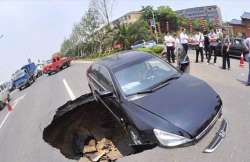 chinese driver has lucky escape as sinkhole swallows his car