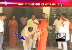 gadkari touches ramdev s feet seeks his blessings