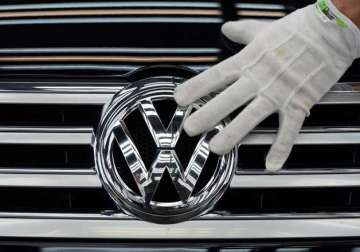 volkswagen suffers first quarterly loss in 15 years lowers forecast due to scandal