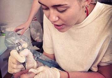 miley cyrus inks her own tattoo artist for fun